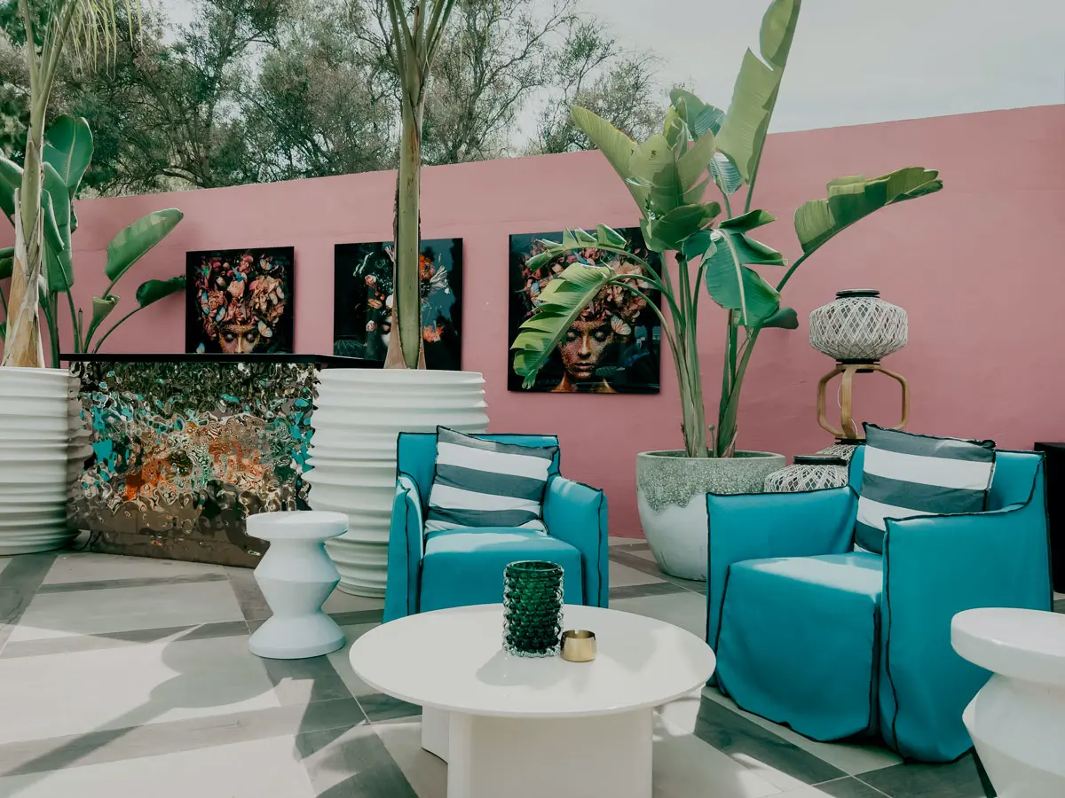 Travelbirds Marbella Pinke Outdoor-Lounge mit blauen Stühlen